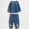 Baby-klädset i blommigt denim