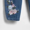 Baby-klädset i blommigt denim