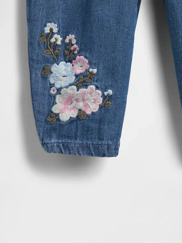 Baby-klädset i blommigt denim