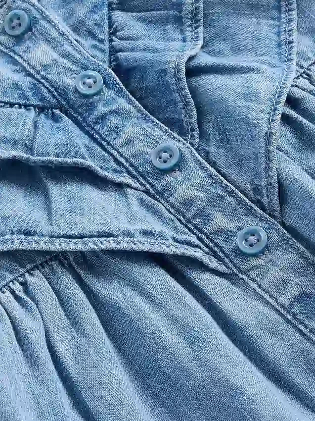 Baby-klädset i denim med volanger