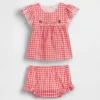 Baby-klädset i gingham med hålbroderi