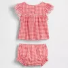 Baby-klädset i gingham med hålbroderi