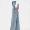 Jeans med medelhög midja, styv passform och avslappnad utsvängd benform