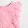 Set med babykläder med hålbroderi och volanger