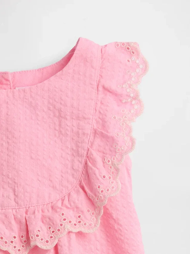 Set med babykläder med hålbroderi och volanger